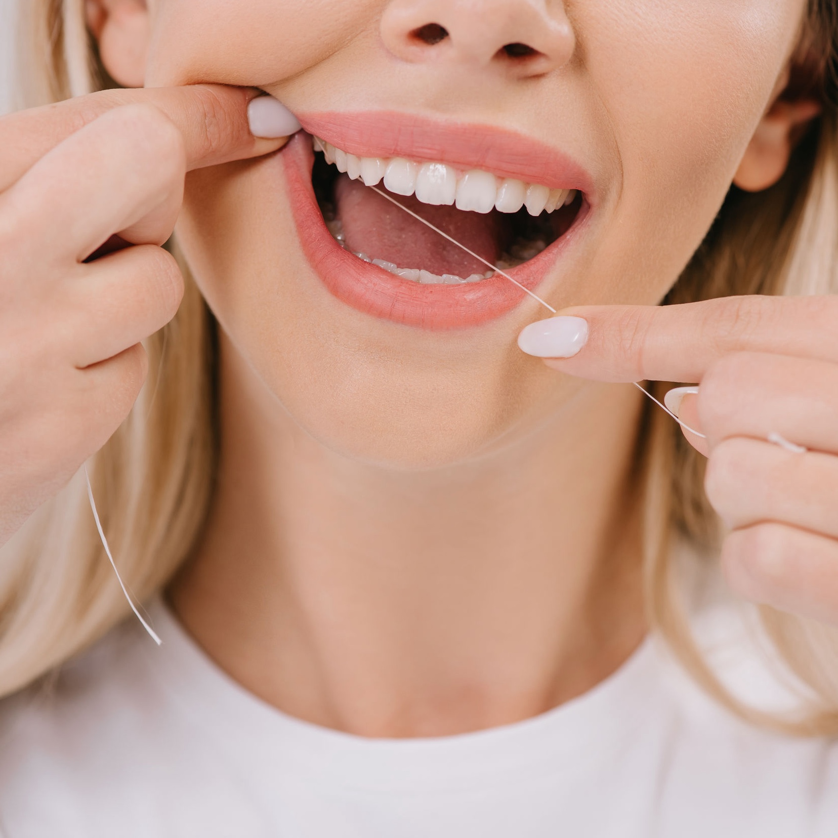 cropped view of woman flossing teeth with dental floss cropped view of woman flossing teeth with dental floss